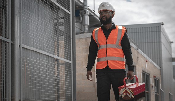 Workman in high vis jacket with tool box