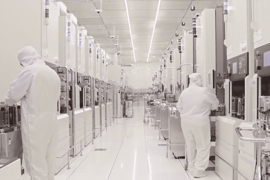 In a non-contamination lab, two men in white lab coats work diligently, ensuring a sterile environment for their project.