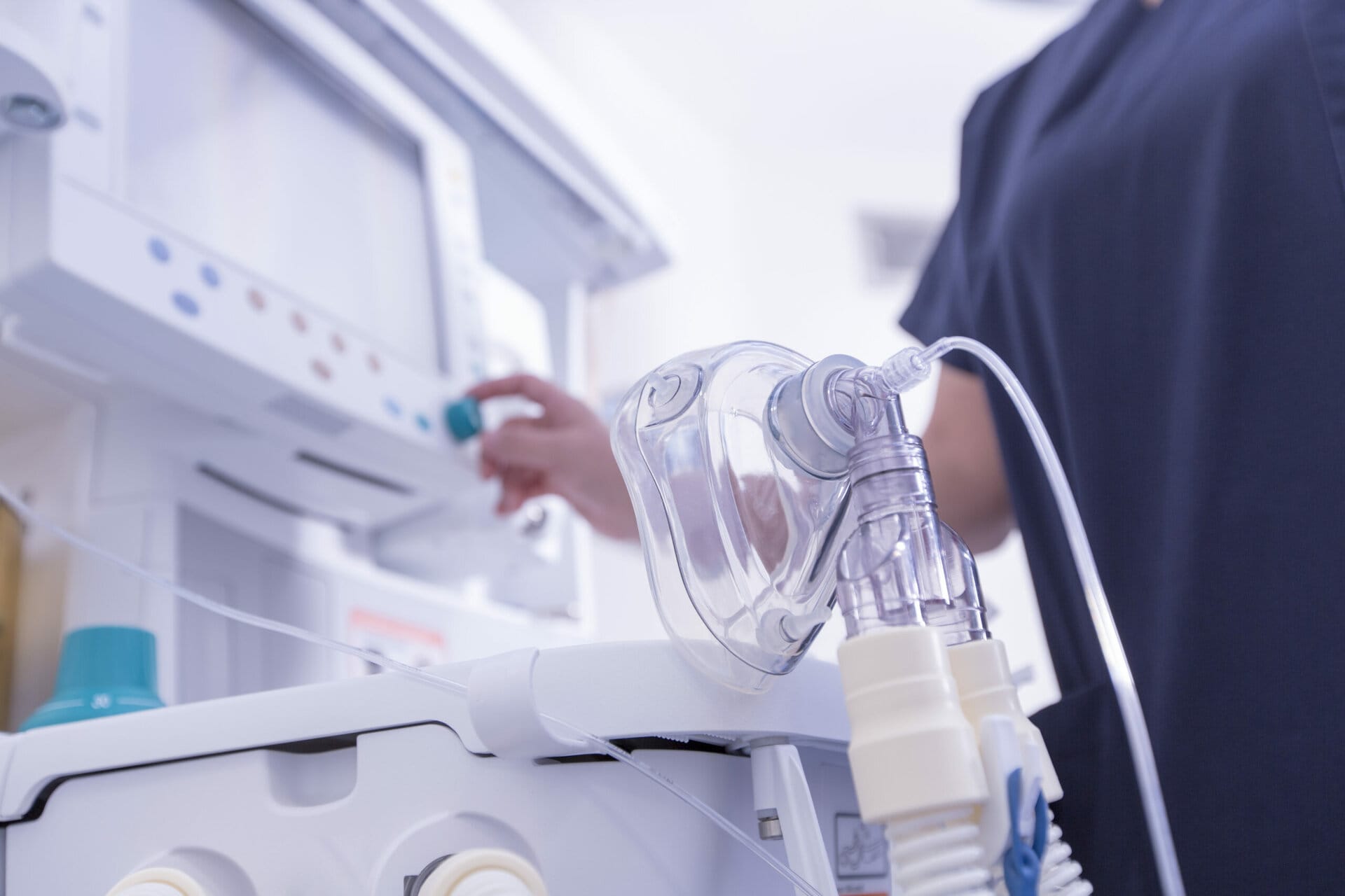 A hospital setting with an oxygen machine for breathing assistance, surrounded by medical equipment and care staff.