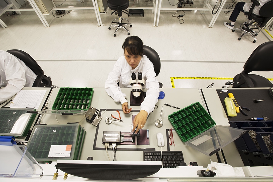 A lab technician examines a sample under a microscope in a modern laboratory setting.